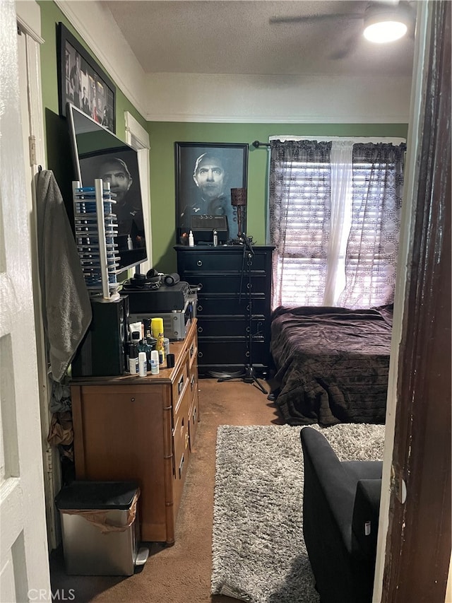 carpeted bedroom with ceiling fan and a textured ceiling