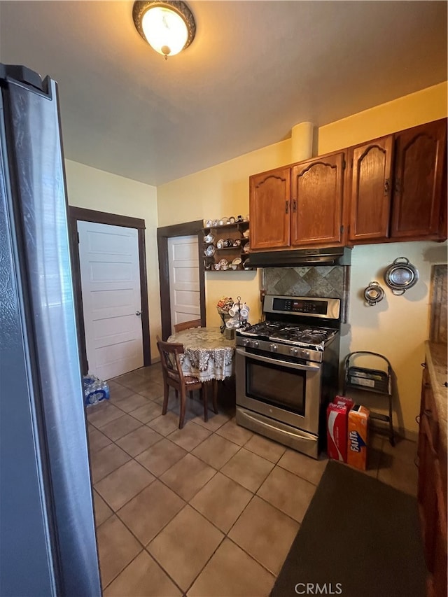 kitchen with backsplash, light tile patterned flooring, and stainless steel gas range