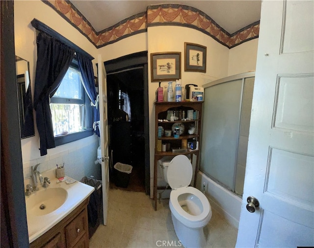 full bathroom with bath / shower combo with glass door, vanity, and toilet