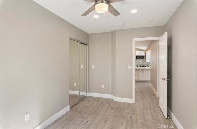 unfurnished bedroom featuring recessed lighting, a closet, visible vents, light wood-style flooring, and baseboards