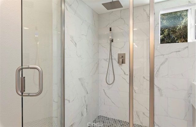 bathroom featuring a marble finish shower