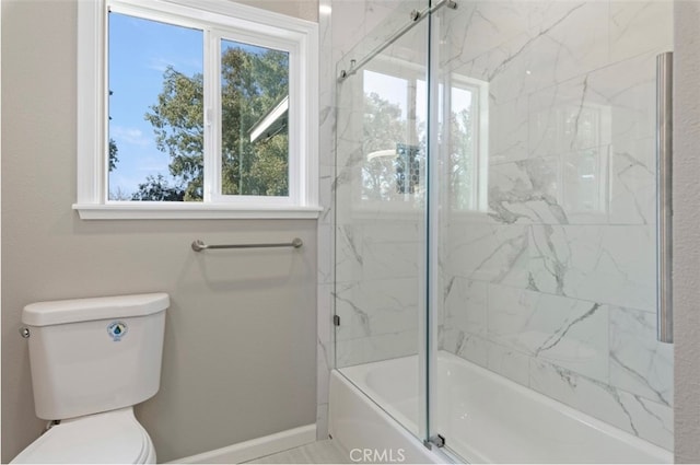 full bath with combined bath / shower with glass door, toilet, and baseboards