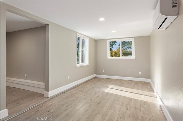 interior space with a wall mounted air conditioner and light wood-type flooring