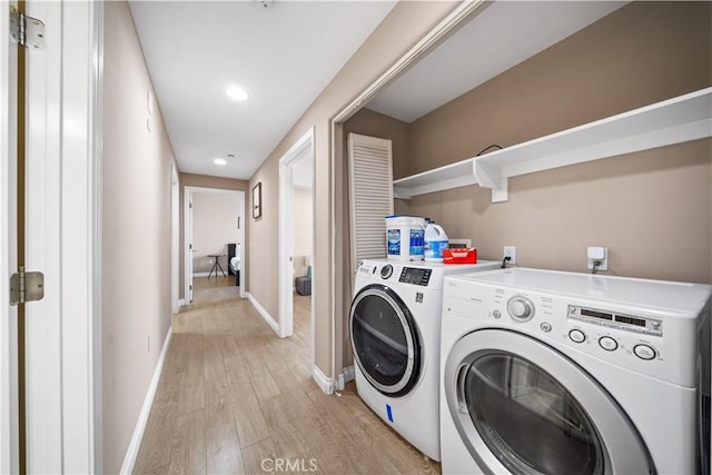 laundry room with independent washer and dryer and light wood-type flooring