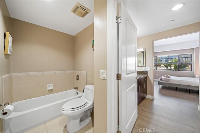 bathroom featuring a bathing tub, vanity, toilet, and hardwood / wood-style flooring