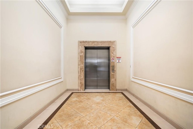 hallway with elevator, crown molding, and light tile patterned flooring