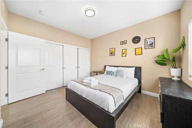 bedroom with light wood-type flooring and a closet