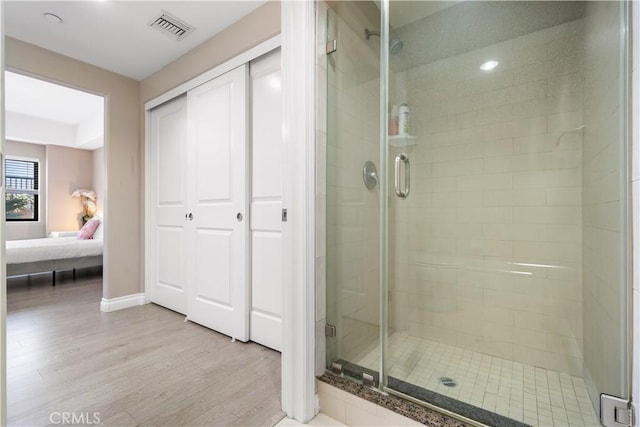 bathroom featuring wood-type flooring and an enclosed shower