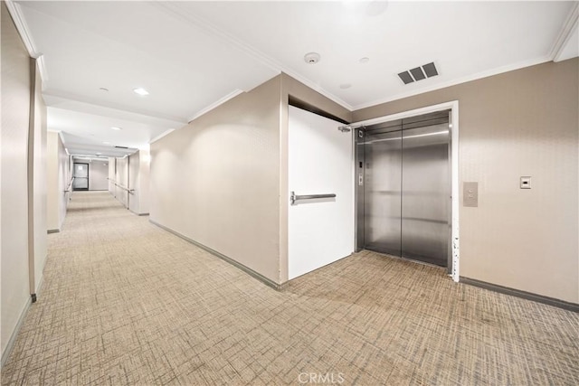 hallway with elevator, crown molding, and light colored carpet