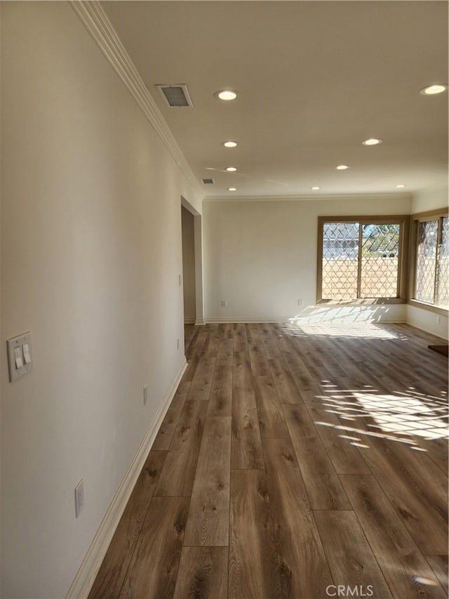 empty room with dark hardwood / wood-style floors and ornamental molding