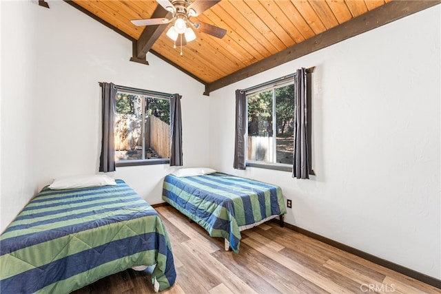 bedroom with ceiling fan, vaulted ceiling with beams, hardwood / wood-style flooring, and wooden ceiling