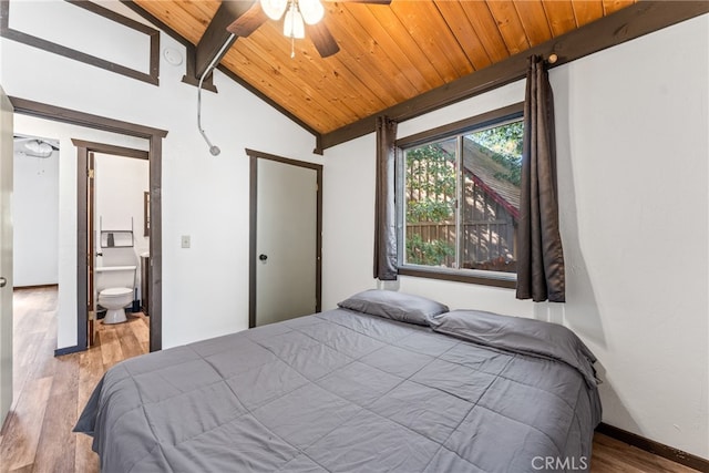 bedroom with ceiling fan, vaulted ceiling with beams, connected bathroom, wooden ceiling, and hardwood / wood-style floors