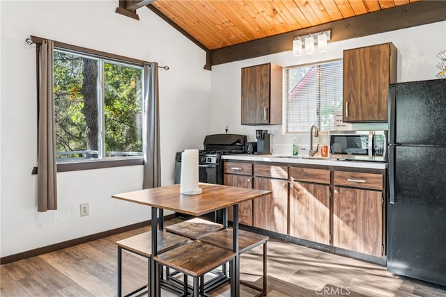 kitchen featuring sink, black appliances, lofted ceiling with beams, wooden ceiling, and light wood-type flooring