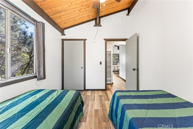 bedroom featuring multiple windows, vaulted ceiling with beams, wood ceiling, and light hardwood / wood-style floors