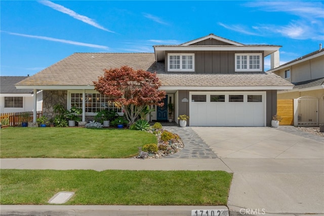 view of property featuring a garage and a front lawn