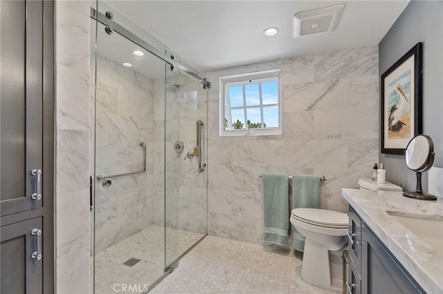 bathroom featuring vanity, toilet, walk in shower, and tile walls