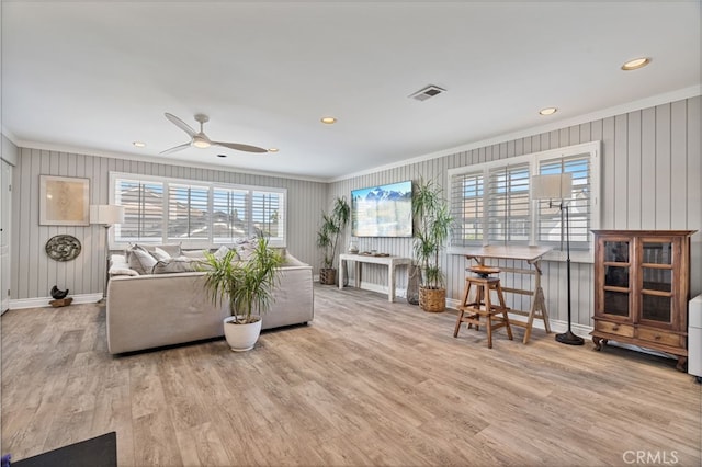 living room featuring light wood-type flooring, ceiling fan, and ornamental molding