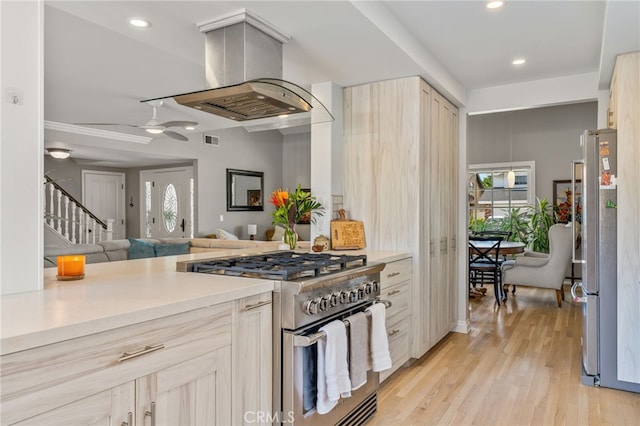 kitchen with light hardwood / wood-style floors, stainless steel appliances, light brown cabinetry, and island range hood