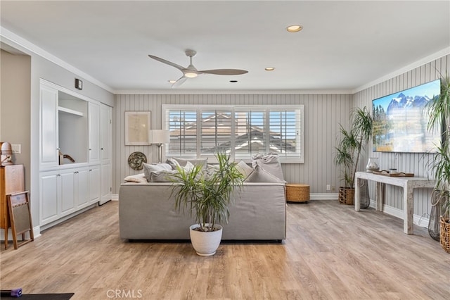 living room featuring light hardwood / wood-style flooring, ceiling fan, and ornamental molding