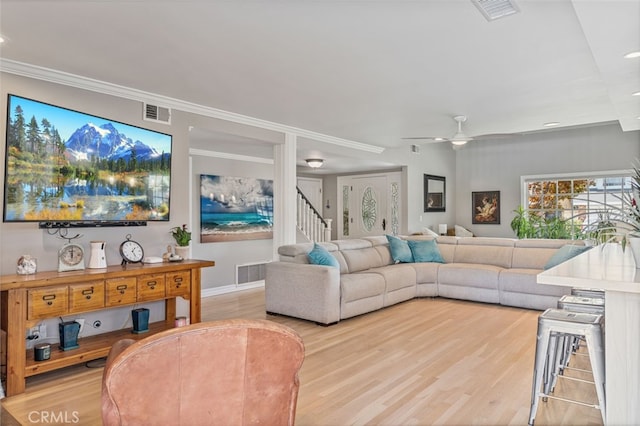 living room featuring light hardwood / wood-style flooring, ceiling fan, and ornamental molding