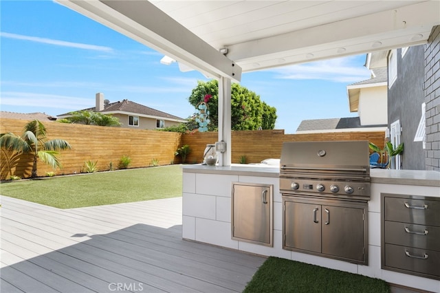 view of patio / terrace featuring area for grilling, a wooden deck, and an outdoor kitchen