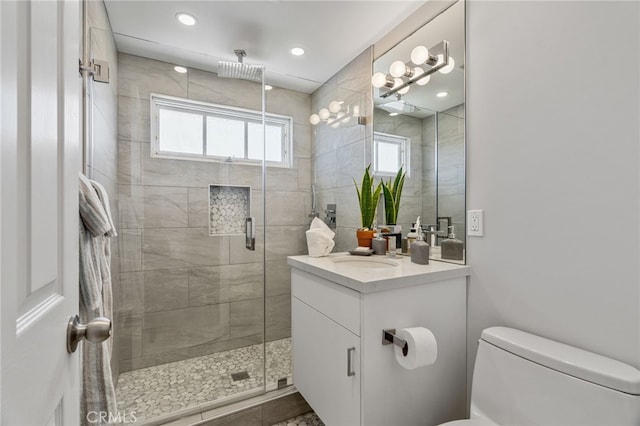 bathroom with tile patterned floors, vanity, toilet, and a shower with shower door