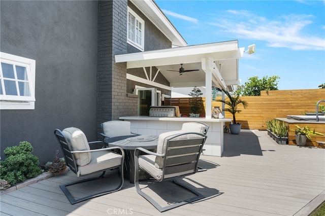 wooden terrace featuring ceiling fan and a bar