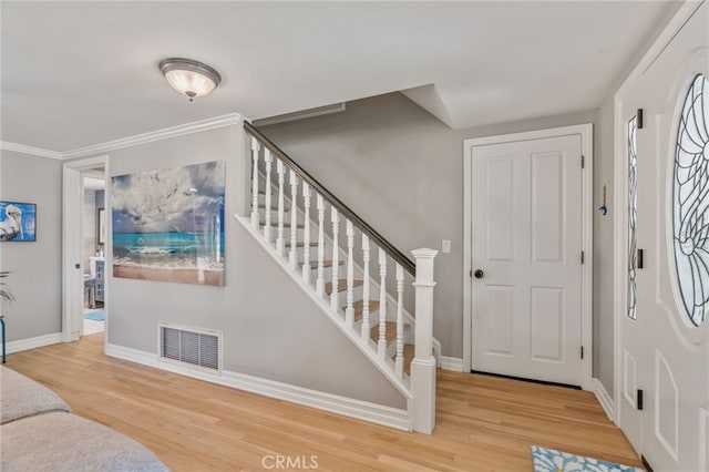 entryway with hardwood / wood-style floors and ornamental molding