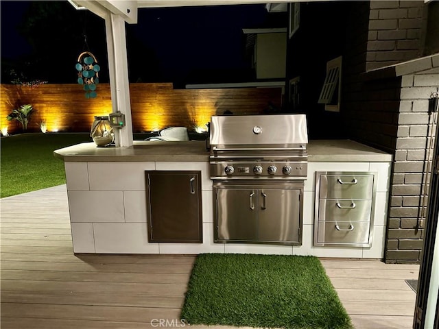 view of patio / terrace with an outdoor kitchen, a deck, and a grill