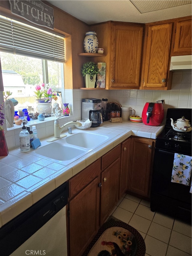 kitchen with black range with electric stovetop, sink, dishwasher, tile counters, and decorative backsplash