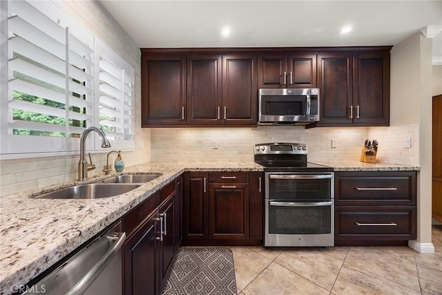 kitchen with decorative backsplash, sink, and stainless steel appliances