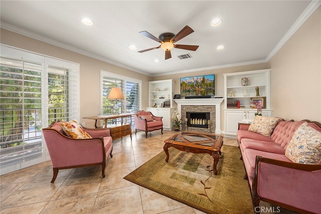 living room with built in features, ceiling fan, a fireplace, and crown molding