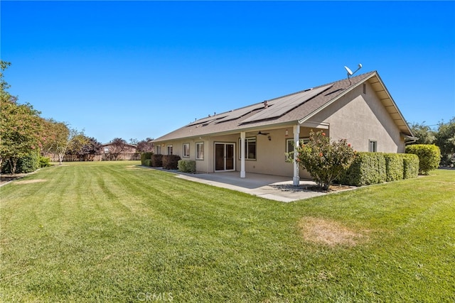 rear view of house with ceiling fan, a yard, and a patio