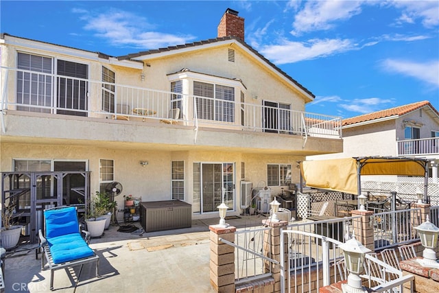 rear view of house with a balcony and a patio