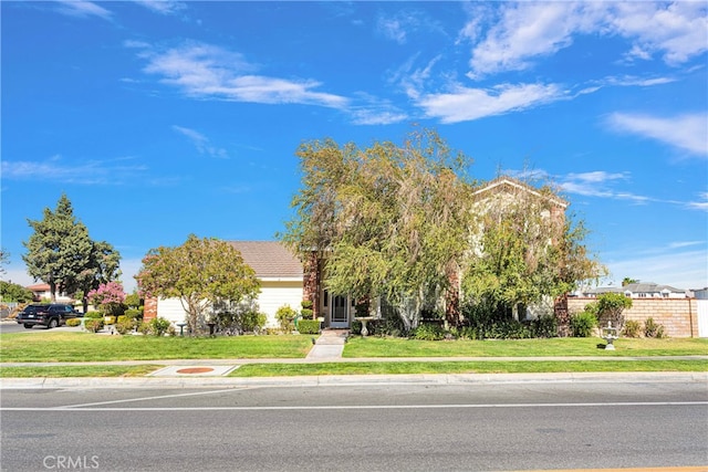 obstructed view of property featuring a front lawn