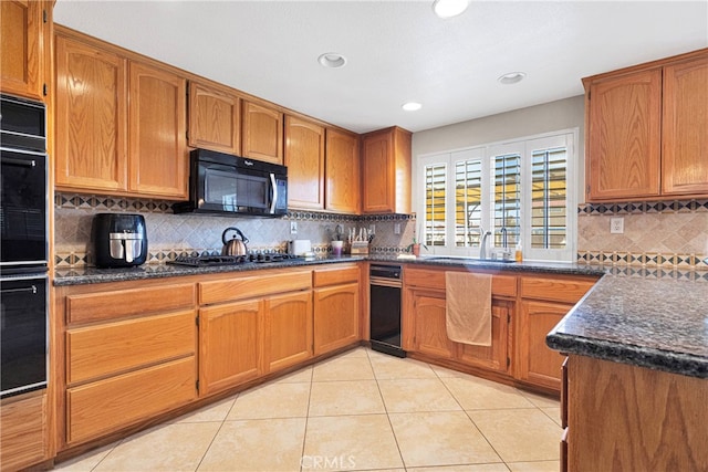 kitchen featuring sink, decorative backsplash, black appliances, and light tile patterned floors