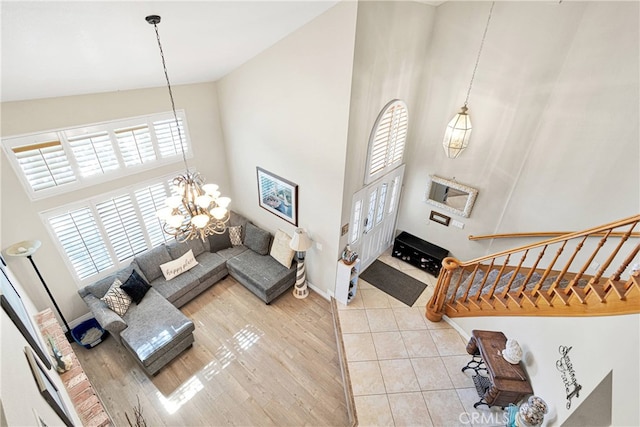 entryway with a notable chandelier, high vaulted ceiling, and light hardwood / wood-style floors