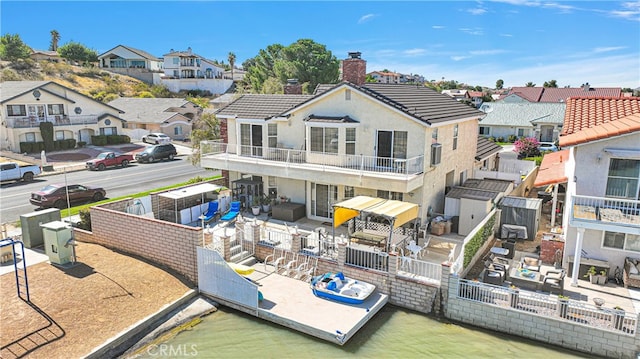 back of property with a balcony and a patio