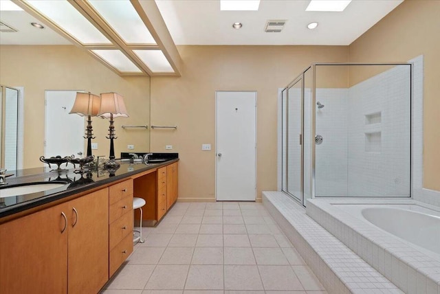 bathroom featuring tile patterned flooring, shower with separate bathtub, and vanity