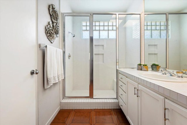 bathroom featuring a wealth of natural light, tile patterned flooring, vanity, and a shower with shower door