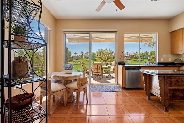 kitchen featuring sink, stainless steel dishwasher, light tile patterned floors, and ceiling fan