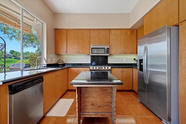 kitchen with a center island, sink, appliances with stainless steel finishes, and light tile patterned floors