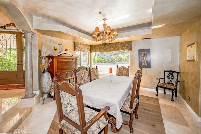 dining area featuring light tile patterned floors, a chandelier, and decorative columns