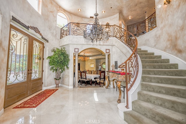 entryway with french doors, a healthy amount of sunlight, a high ceiling, and tile patterned floors