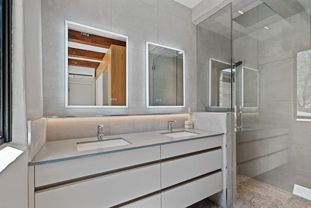 bathroom with tile walls, an enclosed shower, and vanity