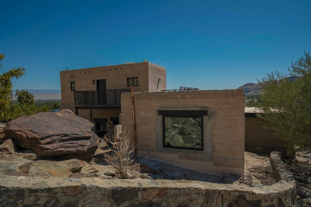 exterior space with a balcony and a mountain view