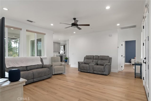 living room with light wood-type flooring and ceiling fan