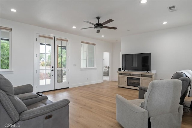 living room with ceiling fan, light hardwood / wood-style flooring, and french doors