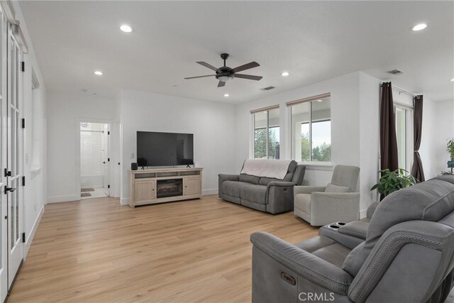 living room with light wood-type flooring and ceiling fan