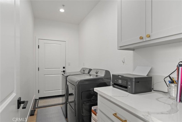 washroom with washing machine and dryer and cabinets